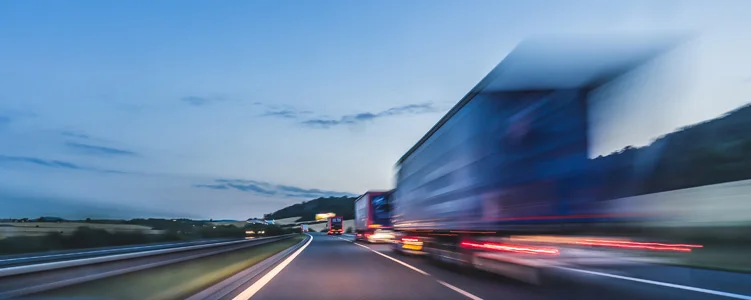 Speeding truck on highway at dusk